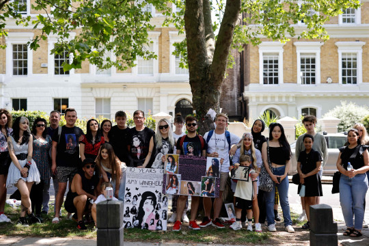 Amy Winehouse Fans Pay Tribute To Late Singer On 10th Anniversary Of Death Amy Winehouse’s family members and fans have gathered at the late singer’s home in North London to pay tribute to her on the 10th anniversary of her death. The musician died on July 23, 2011 at the age of 27 from alcohol poisoning. Pictures have shown a temporary shine situated outside of her house, where supporters have left flowers, balloons and other memorabilia to show their love for Amy. A group of fans also huddled together for a photo, as they posed with two posters which featured images of Amy alongside the words: ‘10 Years Without Amy’. Messages of condolences were also left at the shrine by some, with many expressing their sadness at how long it has been since the singer has gone. Other photos show fans standing alongside Amy’s statue, which is situated in Camden Town.